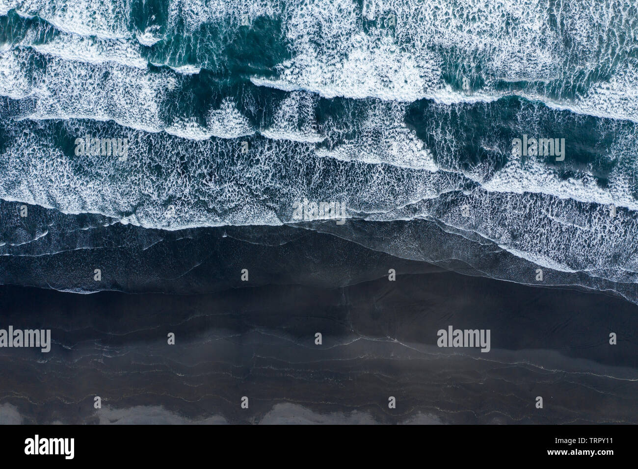 Antenne drone Blick auf den Atlantischen Ozean Wellen spashing Black Sand Beach in Island Stockfoto