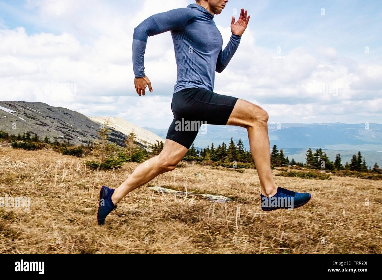 Laufender Mann Athlet run Mountain Trail Seitenansicht Stockfoto
