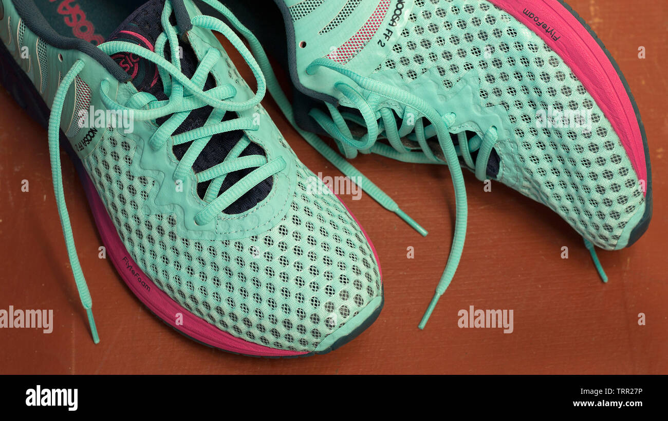 7/8 Schuß von trendigen Asics NOOSA FF 2 Schuhe in Marineblau, Hellblau und Lila Farben für die Ausführung auf terracotta Hintergrund. Moskau - Juni 2019. Fem Stockfoto