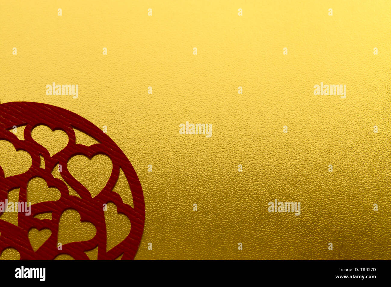 Glänzend gelb Metallic Gold leaf Folie Textur Hintergrund mit geschnitzten roten Herzen. Liebe Karte Stockfoto