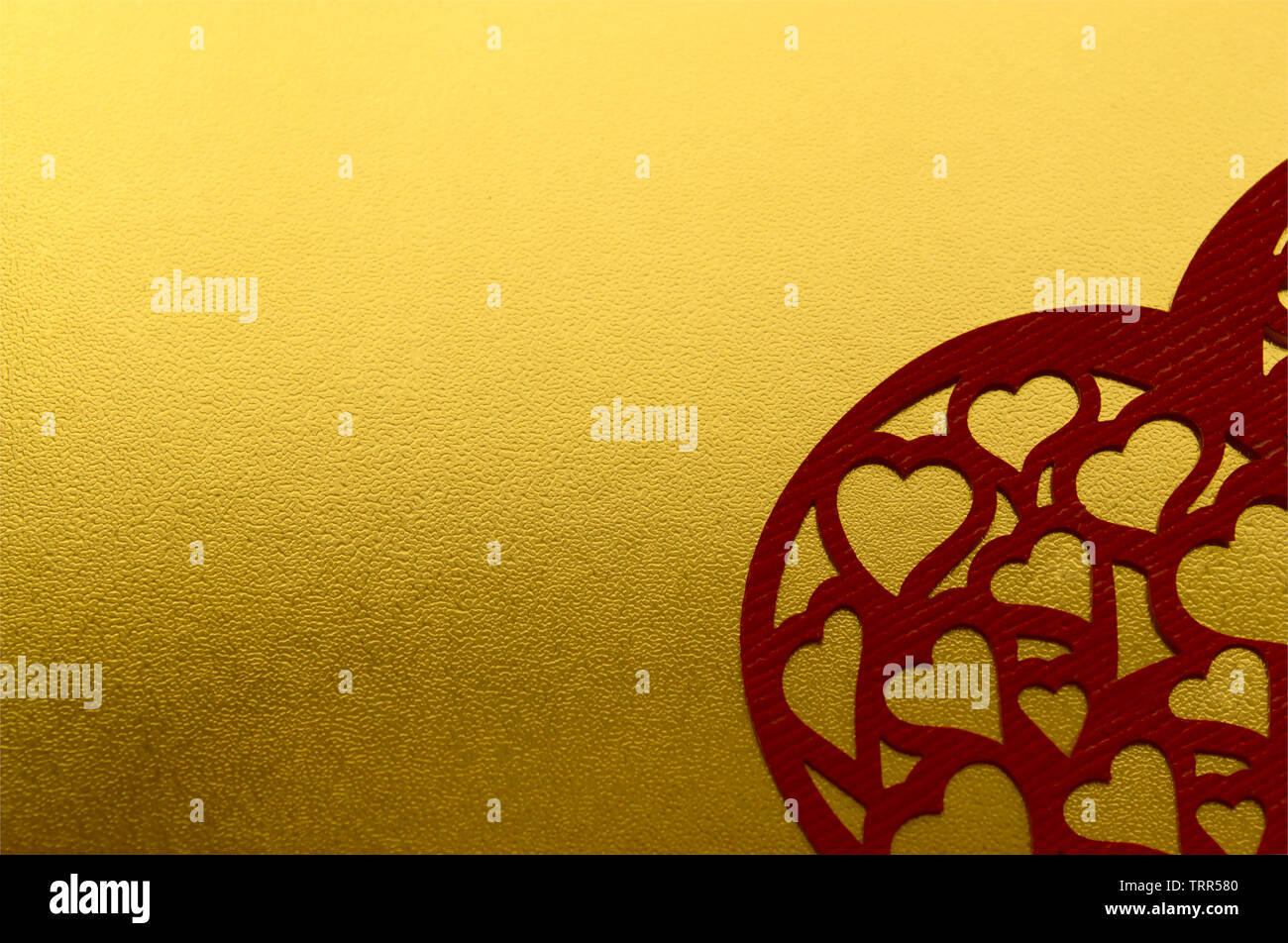 Glänzend gelb Metallic Gold leaf Folie Textur Hintergrund mit geschnitzten roten Herzen. Liebe Karte Stockfoto