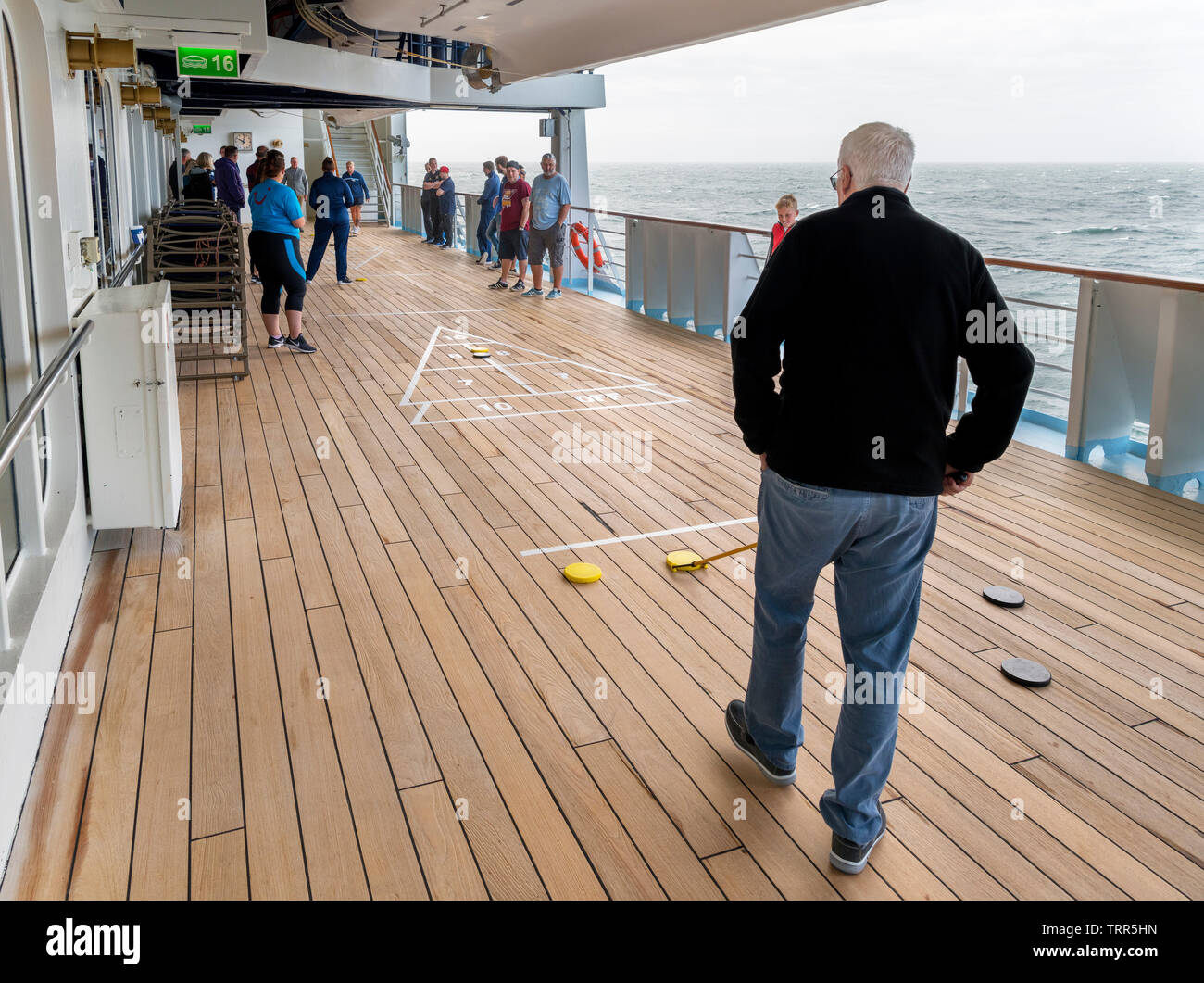 Passagiere Shuffleboard spielen auf dem Deck der TUI Kreuzfahrtschiff Marella Explorer, Nordsee, Europa Stockfoto