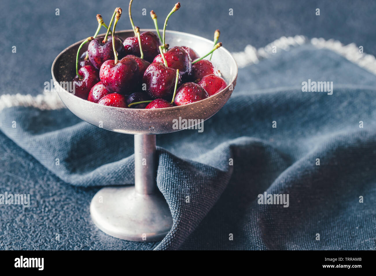 Frische Kirschen in Vintage silver Vase auf dem dunklen Hintergrund Stockfoto