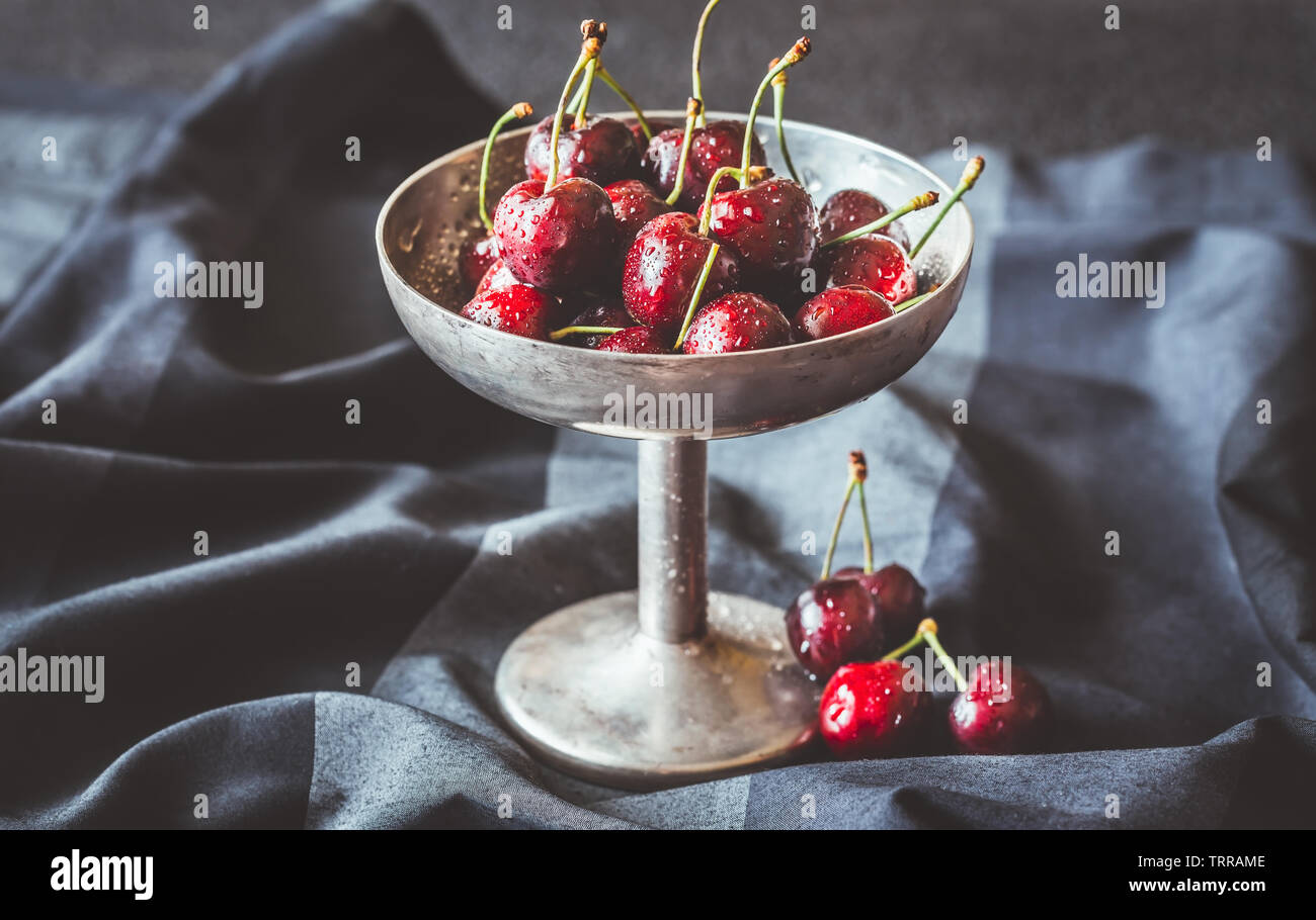 Frische Kirschen in Vintage silver Vase auf dem dunklen Hintergrund Stockfoto