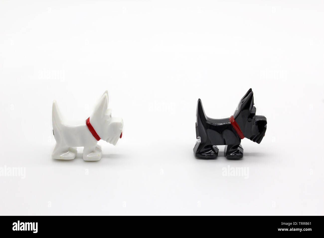 Zwei schwarze und weisse Hund Kunststoff Miniaturen, auf weißem Hintergrund, Nahaufnahme Stockfoto