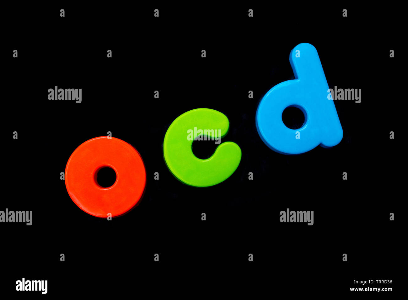 Die Abkürzung OCD (Obsessive Compulsive Disorder) Dinkel mit bunten Buchstaben auf schwarzem Hintergrund. Stockfoto