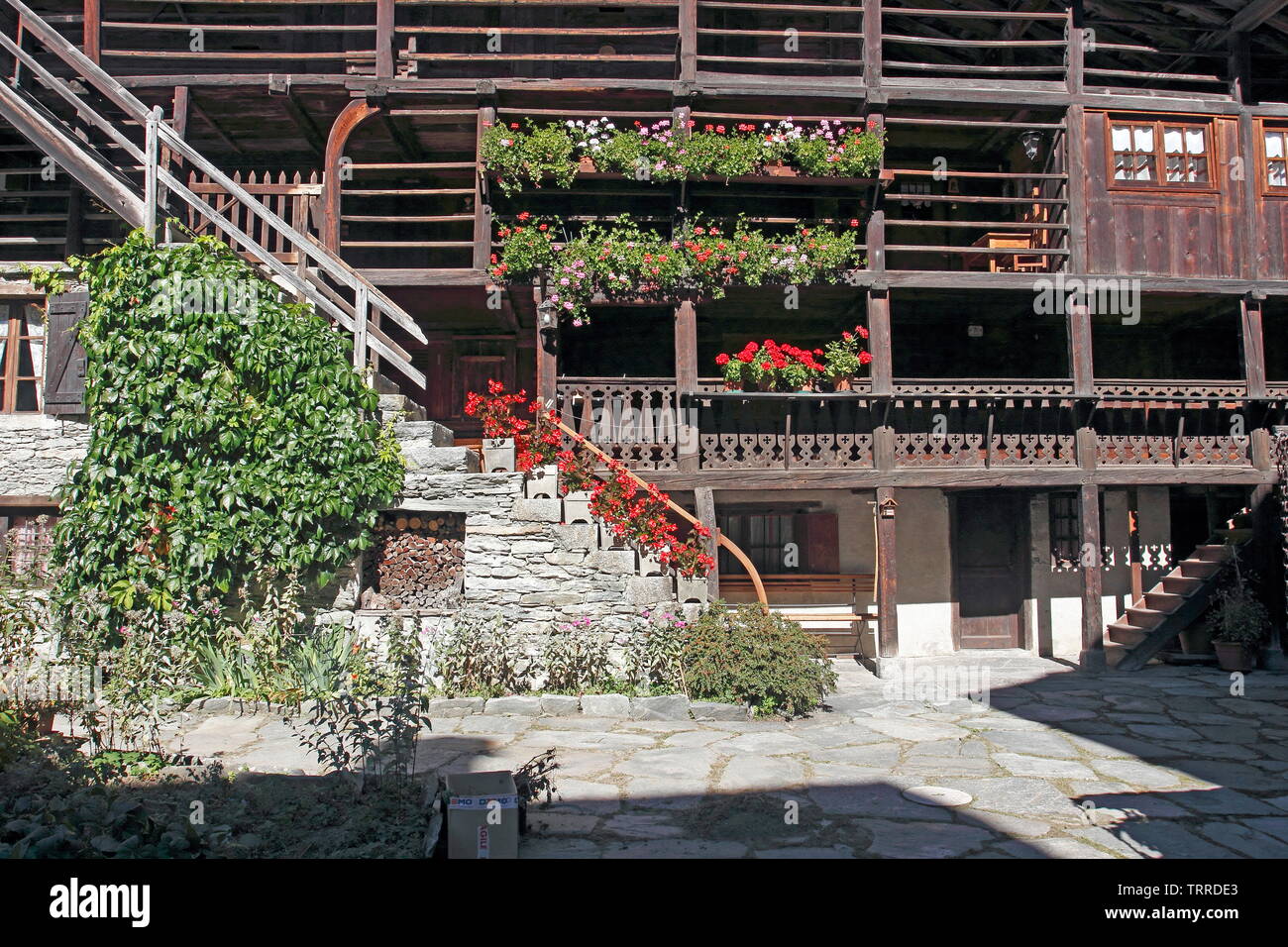 Italien Piemont Seen Lago d'Giulio italienischen Alpen Alagna Valsesia Tal traditionelle Walser Holz Gebäude mit roten Blumen Geranien Architektur Stockfoto