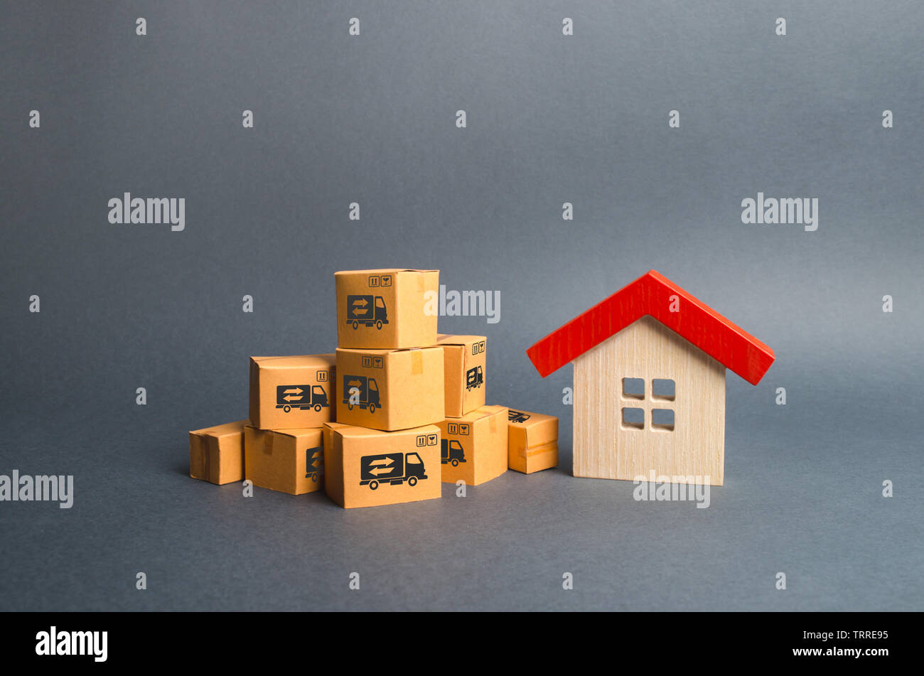 Ein Stapel von Kartons und ein Holzhaus. Konzept der Umzug in ein anderes Haus oder der Stadt. Unterkunft Transport. Fracht-, Liefer- und inst Stockfoto