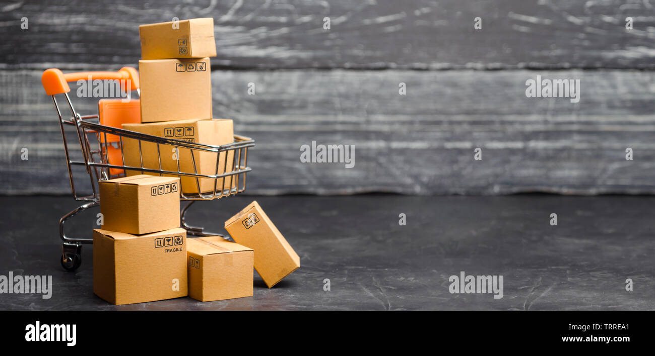 Schubkarre Supermarkt mit Boxen. Der Verkauf von Produkten. Der Begriff Handel, On-line-Einkaufen. E-Commerce, Vertrieb und Verkauf von Waren durch on-line-tra Stockfoto