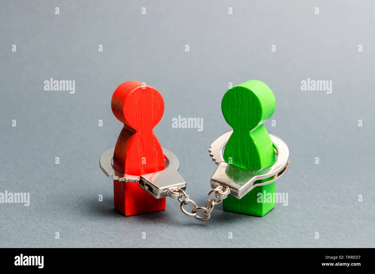 Zwei Menschen sind untereinander mit Handschellen gefesselt. Nicht geschlossene Verpflichtungen zwischen zwei Personen, finanzielle oder moralische Schuld. Vertrag, Pflicht, Verantwortung und Pflicht. K Stockfoto