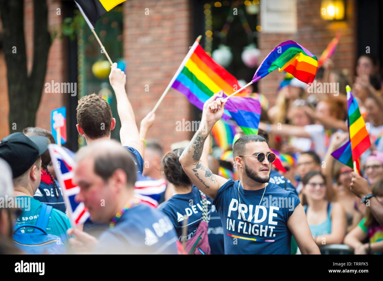 NEW YORK CITY - 25. Juni 2017: Die Teilnehmer tragen Hemden von Delta und Virgin Atlantic Airlines wave Regenbogenfahnen in der Gay Pride gesponsert wird, Stockfoto