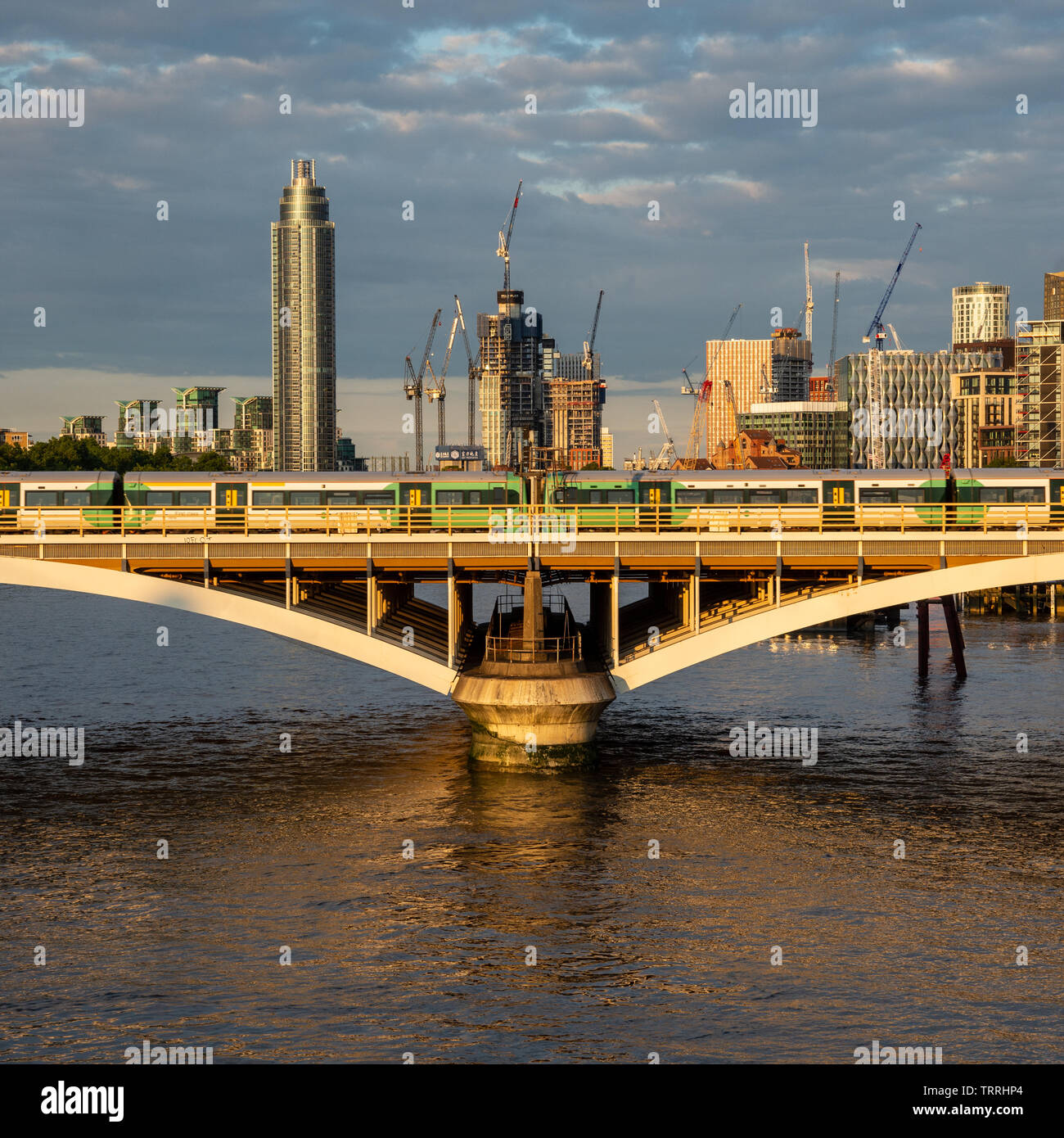 London, England, UK - 28. Mai 2019: Eine südliche Züge der S-Bahn überquert den Fluss Themse in der Nähe von Victoria Station mit neuen Hochhäusern unter Stockfoto