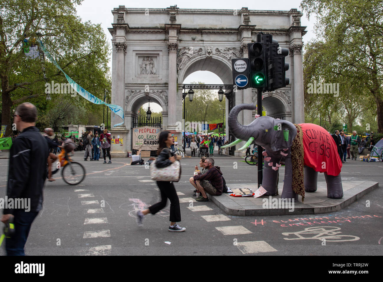 London, England, Großbritannien - 23 April, 2019: Radfahrer und Fußgänger durch einen Protest Camp vom Aussterben Rebellion bei Marble Arch in London. Stockfoto