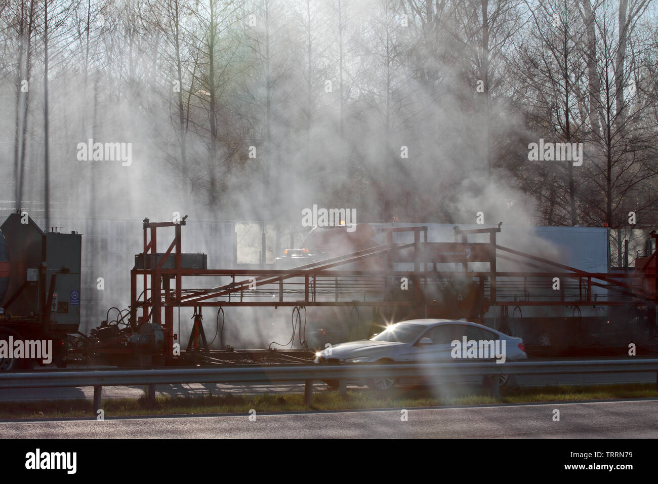 Hameenlinna Finnland 05/04/2016 Die Autobahn ist unter ebnet mit Asphalt. Die asphaltierung Maschinen und Lastwagen sind langsam nach vorn bewegen. Die Luft ist voller Stockfoto