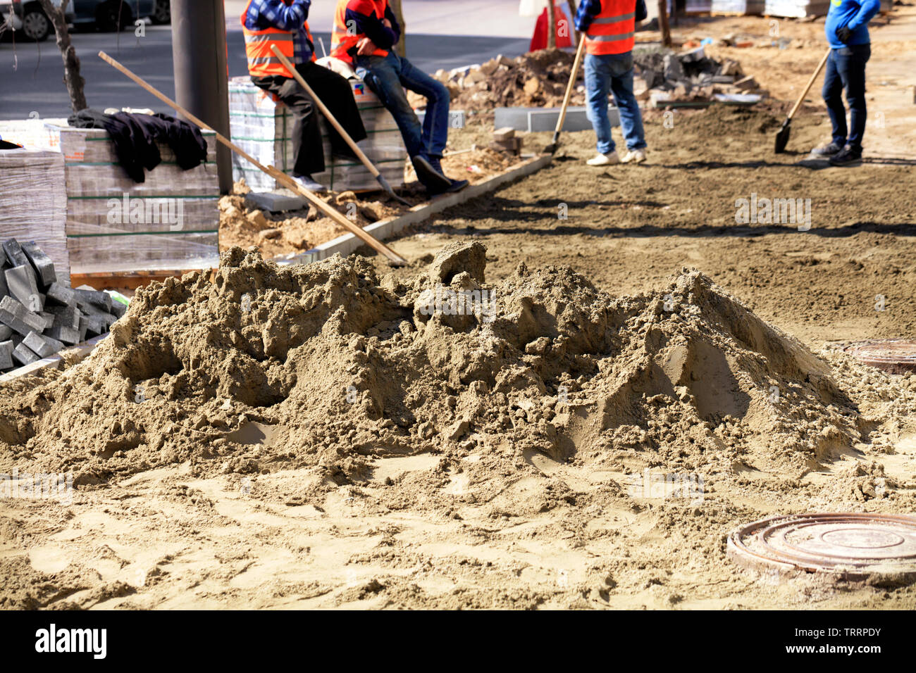 Zement-sand-Gemisch auf dem Hintergrund der Stapel von Platten und die Arbeitsgruppe in den Prozess der Reparatur dem Bürgersteig. Stockfoto