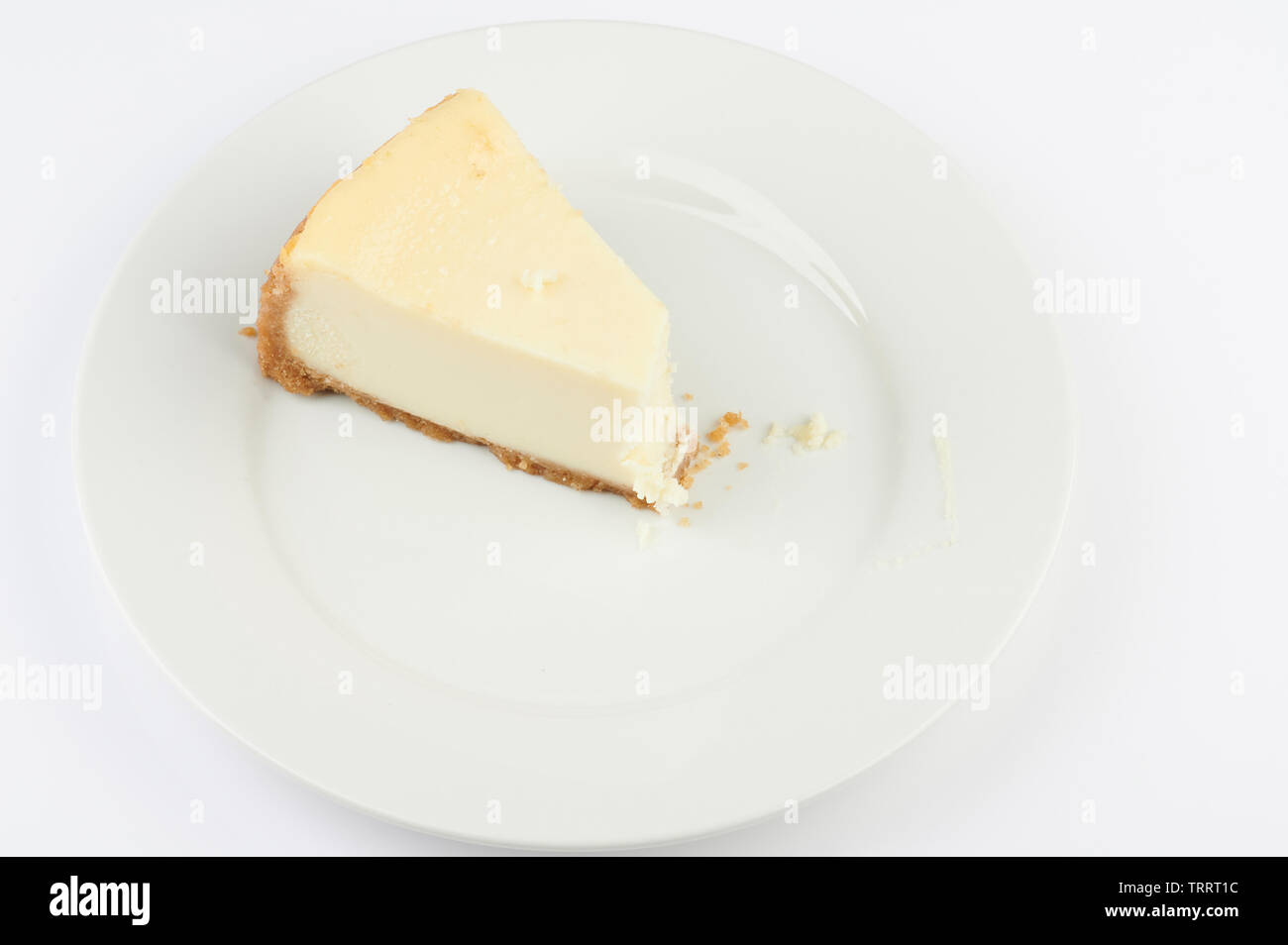 Stück Käsekuchen mit Biss auf Platte isoliert Stockfoto