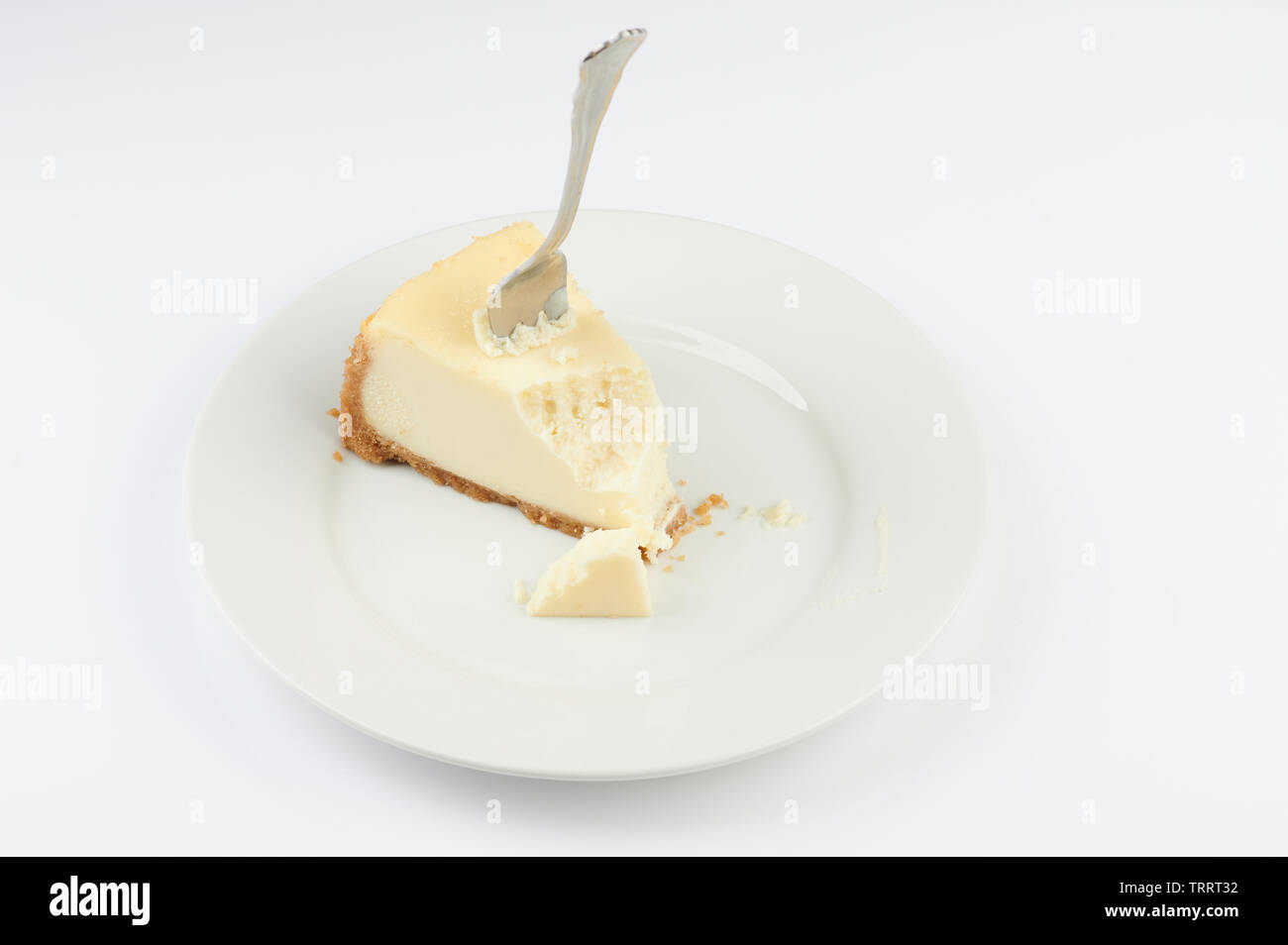 Gabel klemmt in der cheesecake mit Biss auf Platte isoliert Stockfoto