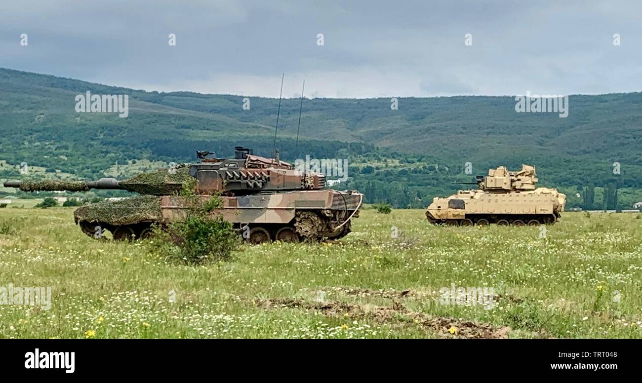 Einen bulgarischen Landstreitkräfte T-72 Tank und einer U.S. Army Bradley Fighting Fahrzeug aus 1.Bataillon, 16 Infanterie Regiment Fahrpositionen während Schlagen zurück 19 am bulgarischen Landstreitkräfte" Novo Selo Training Bereich zu kämpfen, 11. Juni 2019. Schlagen zurück 19 ist eine multinationale Übung veranstaltet von der bulgarischen Streitkräfte bei Novo Selo, Bulgarien, von Juni 6-20, 2019. Schlagen zurück 19 wurde entwickelt, um Fähigkeiten und interoperabilities mit bulgarischen, Albanisch, Griechisch, Mazedonisch Norden und US-Truppen. (U.S. Armee Foto von Cpt. Erica Mitchell) Stockfoto