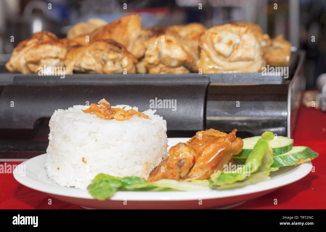 Schale mit indonesischen Essen, gegrilltem Hähnchenfleisch in Rujak Sauce mit Gurken, grüne Blätter Salat und Reis. Botschaft Street Food Festival im Stockfoto