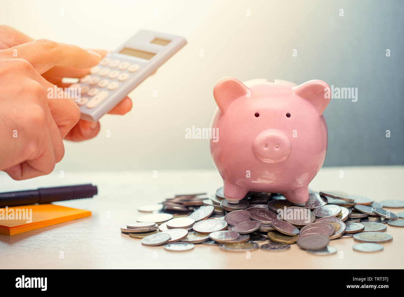 Hand berechnen Geld sparen mit Piggy Bank konto Ertrag und Gewinn mit Taschenrechner Stockfoto