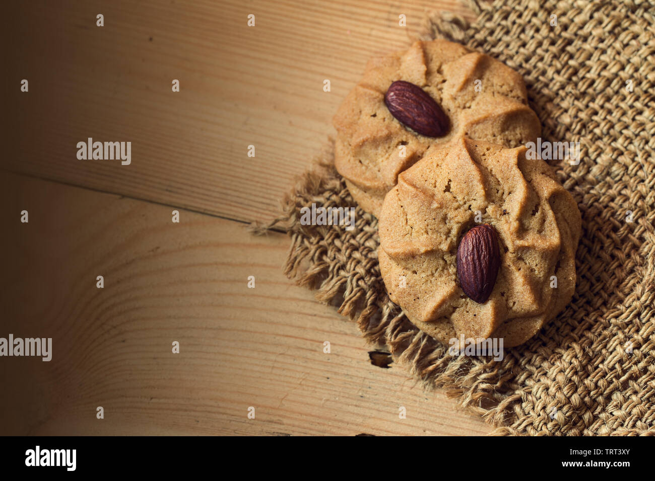 Almond Cookies mit Mandel- Muttern auf hölzernen Tisch Hintergrund mit Platz für Text Stockfoto