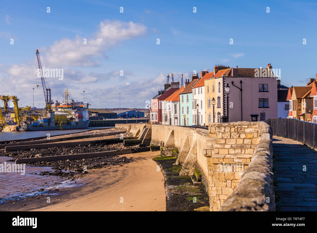 Der Strand, das Meer Mauern und Häuser mit den Kranichen im Hintergrund am Vorgewende, Alte Hartlepool, England, Großbritannien Stockfoto