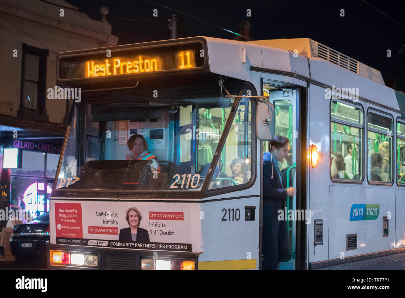 Eine Person aussteigen (Aussteigen) ein modernes Melbourne tram Richtung West Preston auf der Brunswick Street, Fitzroy, Victoria, Australien in der Nacht Stockfoto