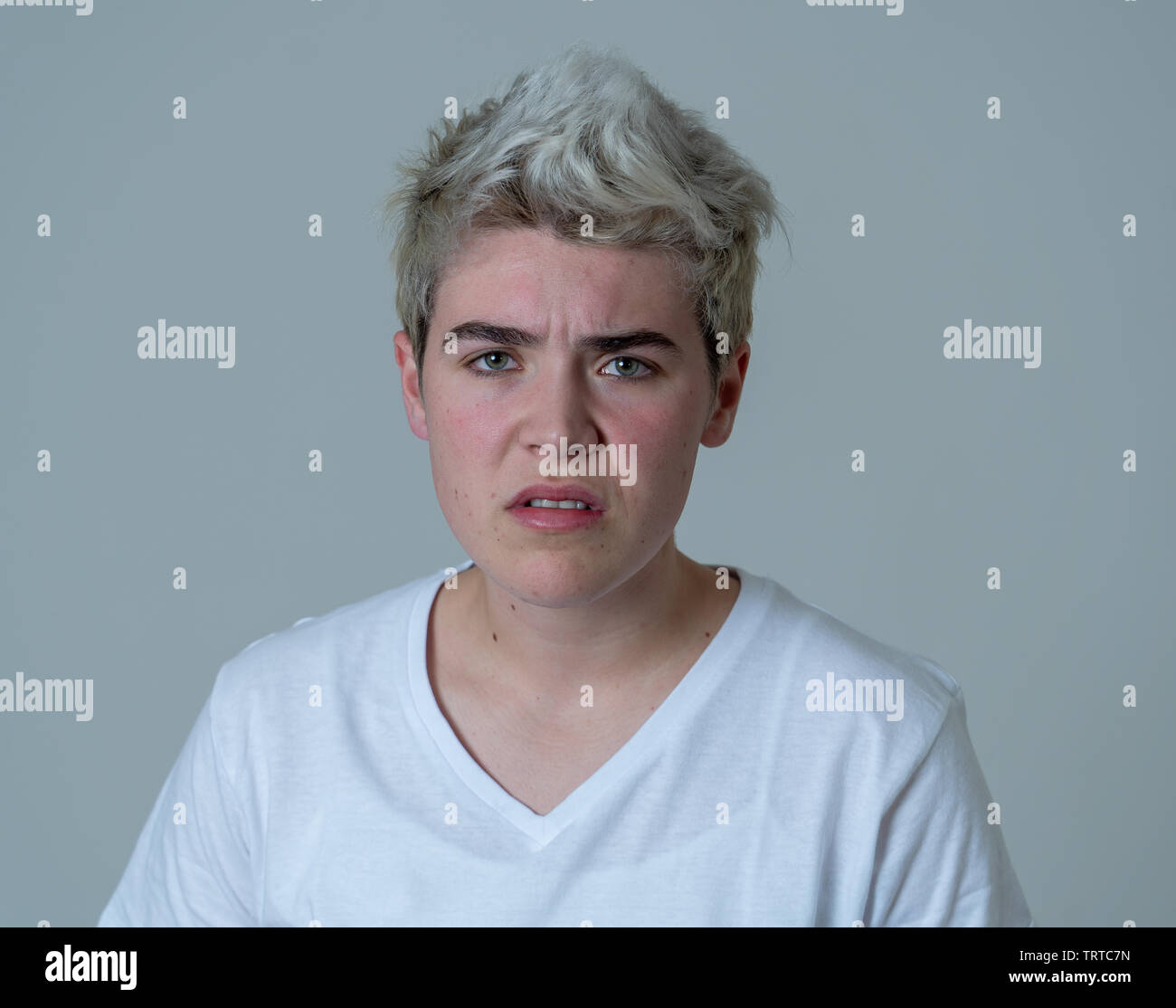 Porträt der jungen attraktiven transgender Teenager Mann mit wütend das Gesicht. Suche sauer und wütend. Mimik und Emotionen. Auf isoliertem Sternpunkt b Stockfoto