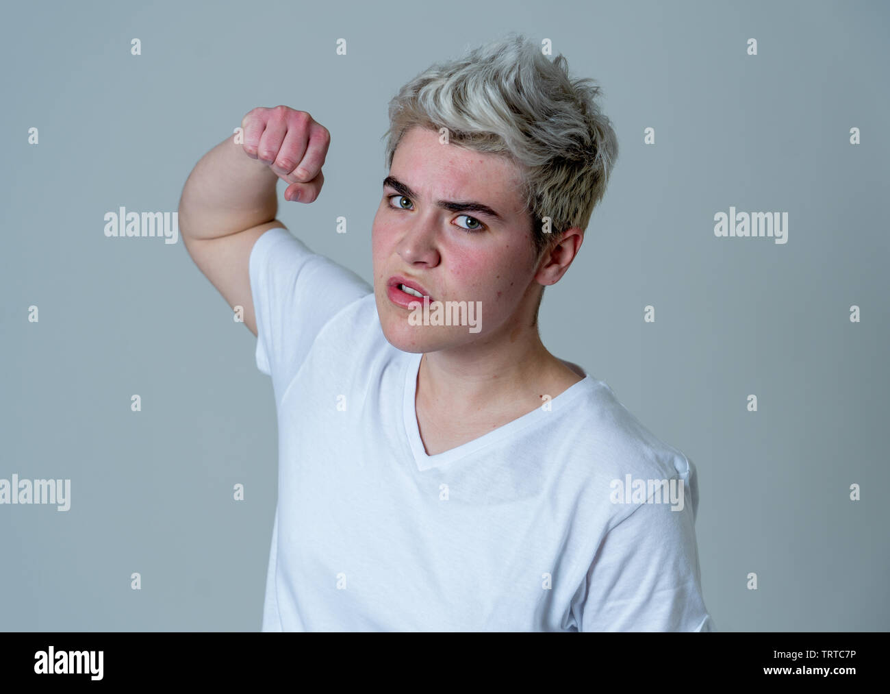 Porträt der jungen attraktiven transgender Teenager Mann mit wütend das Gesicht. Suche sauer und wütend. Mimik und Emotionen. Auf isoliertem Sternpunkt b Stockfoto