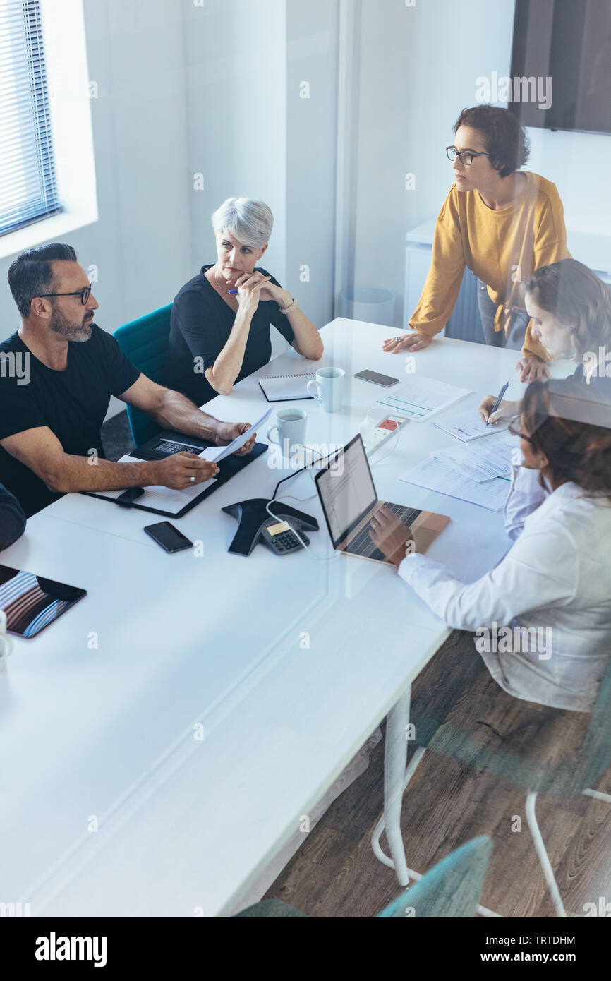 Ein Team von Profis, das eine Besprechung im Sitzungssaal abhält. Geschäftsteam, das ein Brainstorming-Meeting in einem modernen Büro abhält. Stockfoto