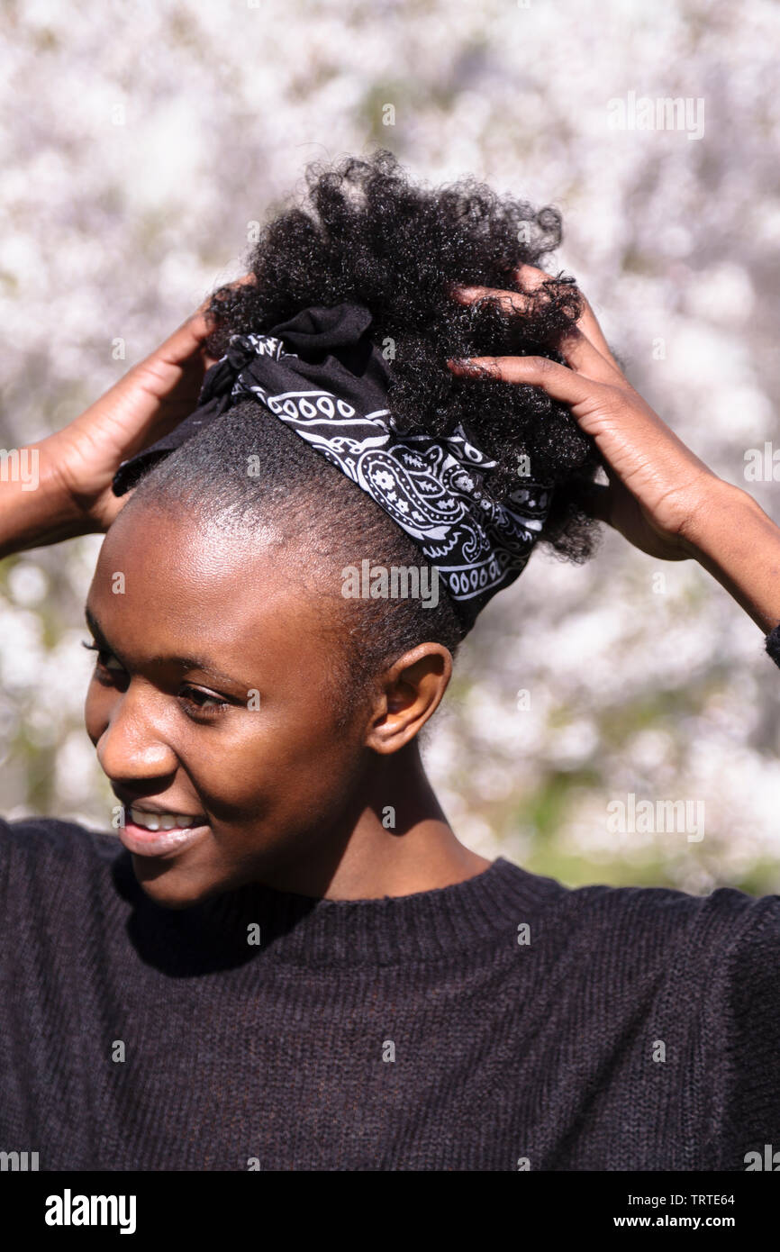 Junge Afrikanische Amerikanische Madchen In Der Blute Park Sieht Seitwarts Und Fixes Frisur Stockfotografie Alamy