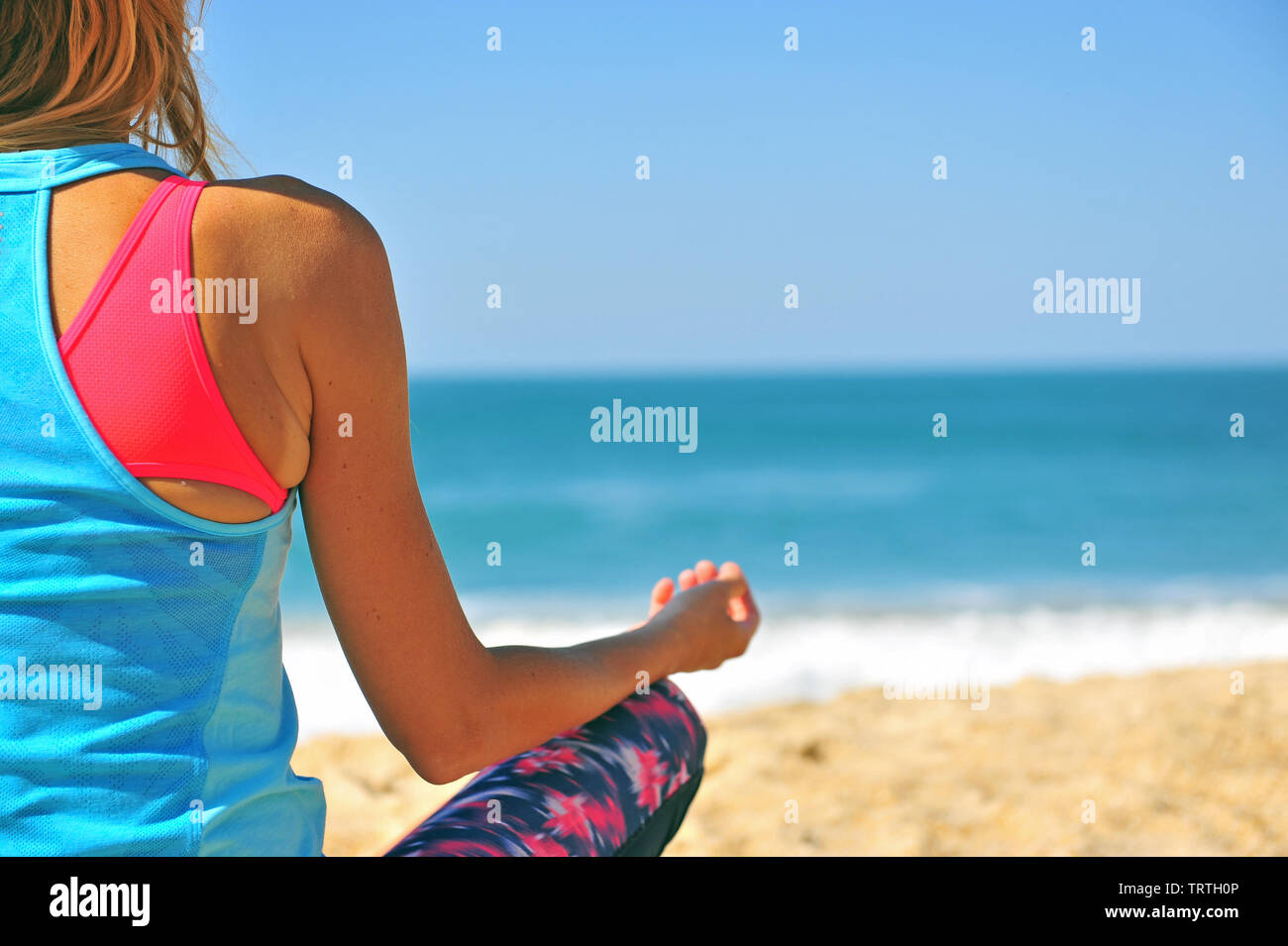 Athletische Frau am Strand zu sitzen und auf das Meer Stockfoto