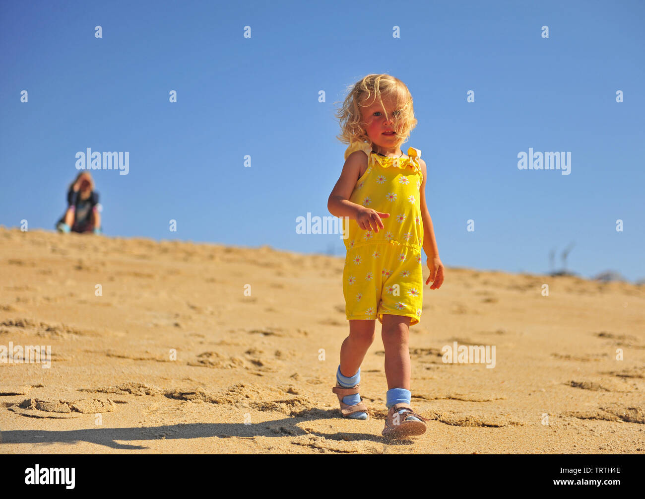 Kleine blonde Mädchen zu Fuß am Strand Stockfoto