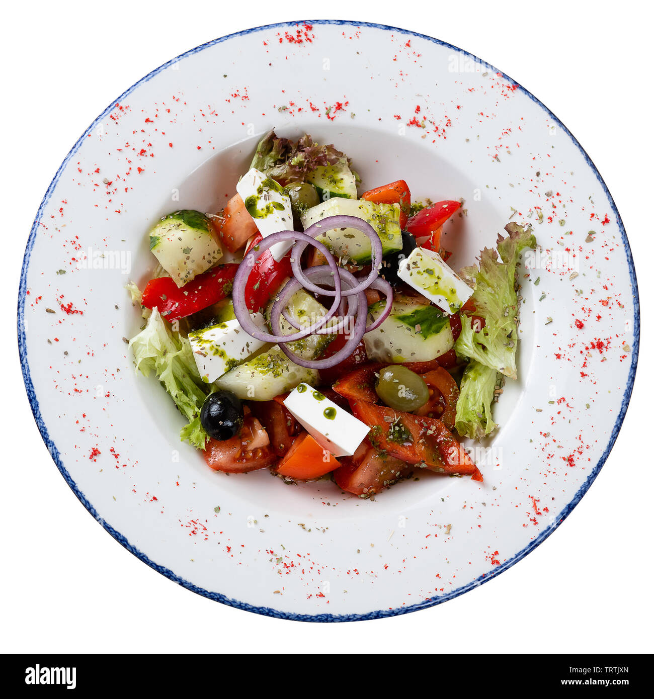 Griechischer Salat in einem runden Teller auf einem weißen Hintergrund. Salat von Tomaten, Gurken, Käse, Kräuter, gewürzt mit Öl Stockfoto