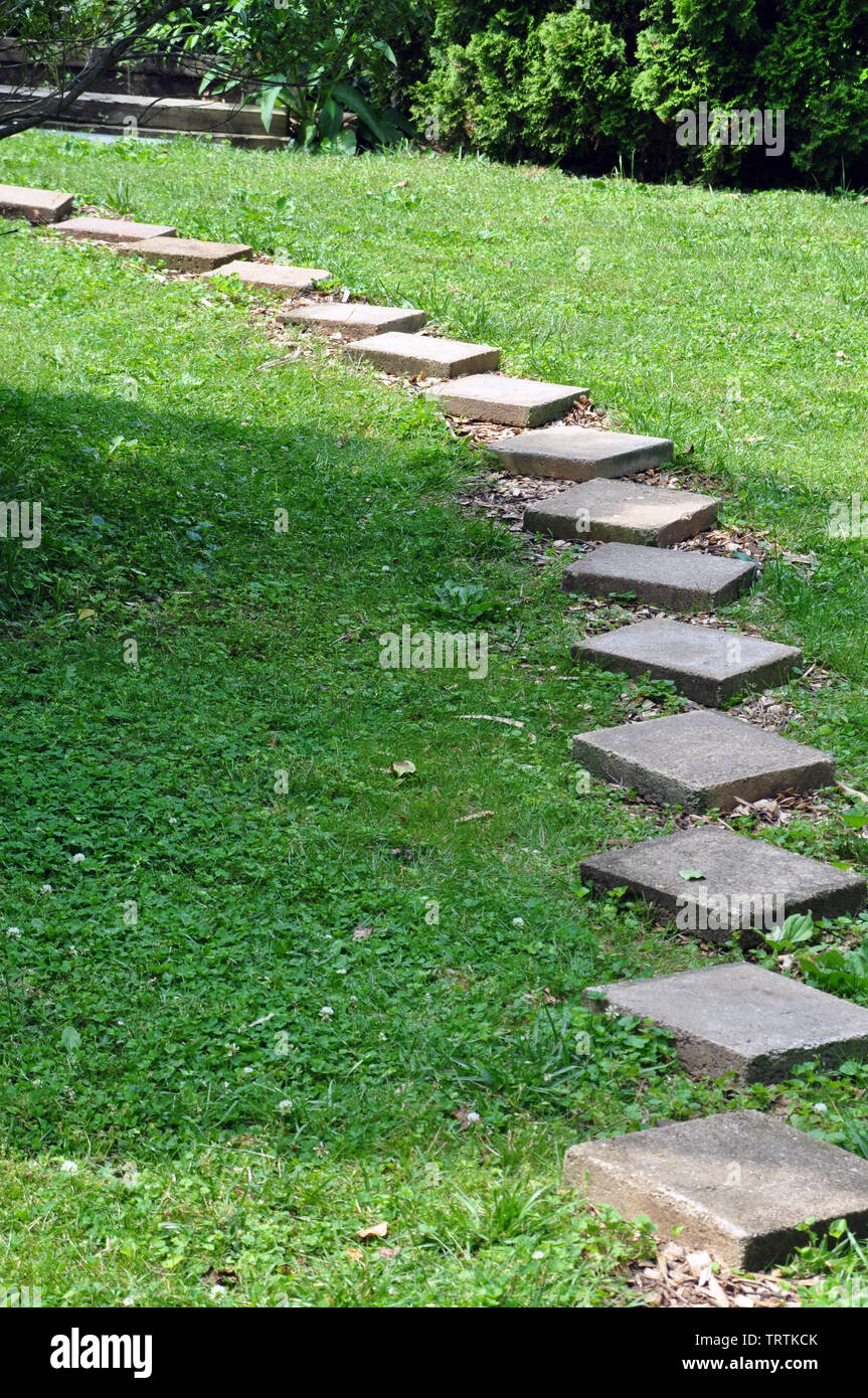 Platz Betonklotz Gehweg durch das Gras in einem Hinterhof Stockfoto