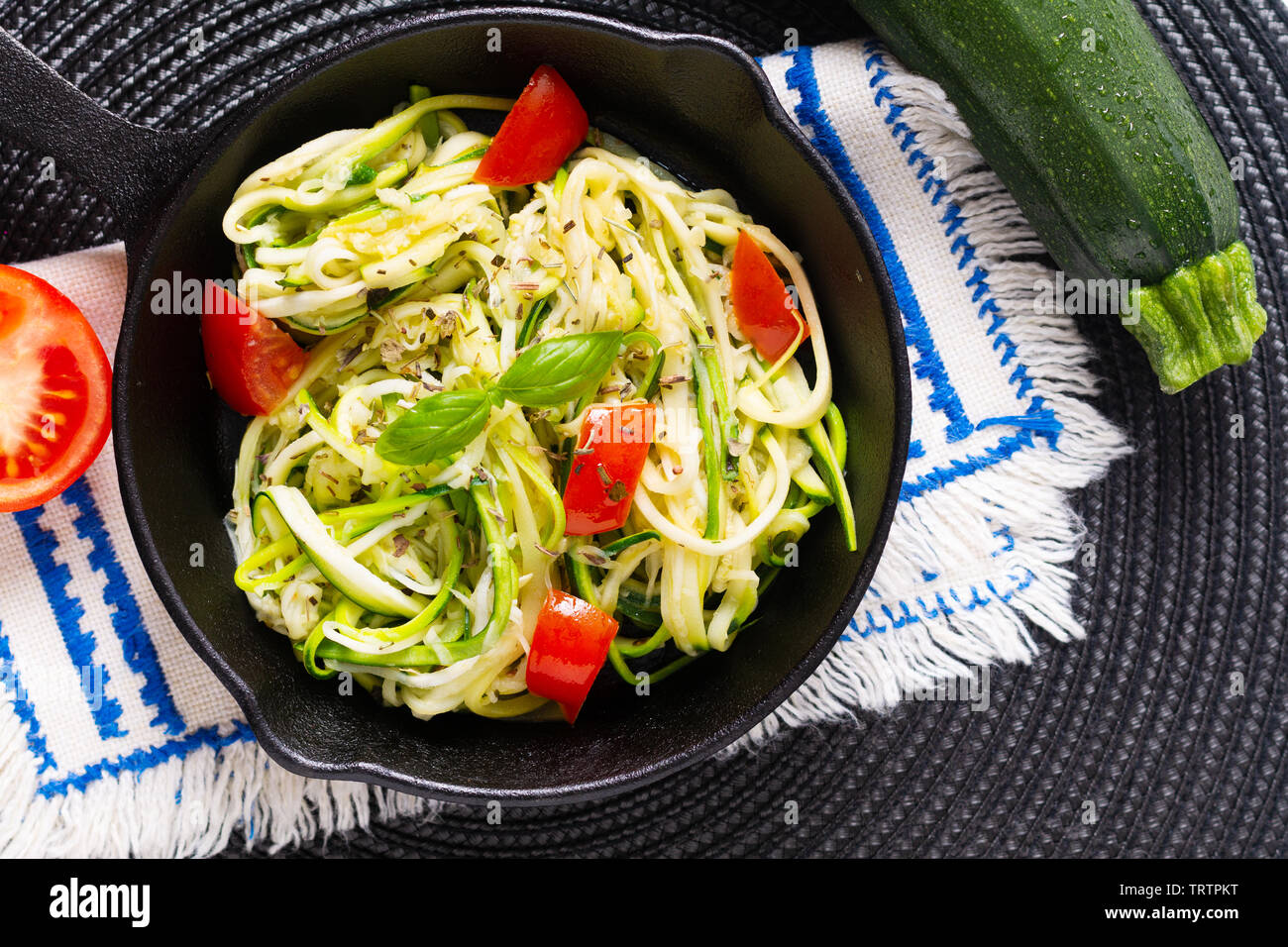 Gesunde Ernährung Konzept hausgemachte Guilten-Free Zucchini Nudeln, Pasta mit Tomaten in Iron skillet Pan Stockfoto