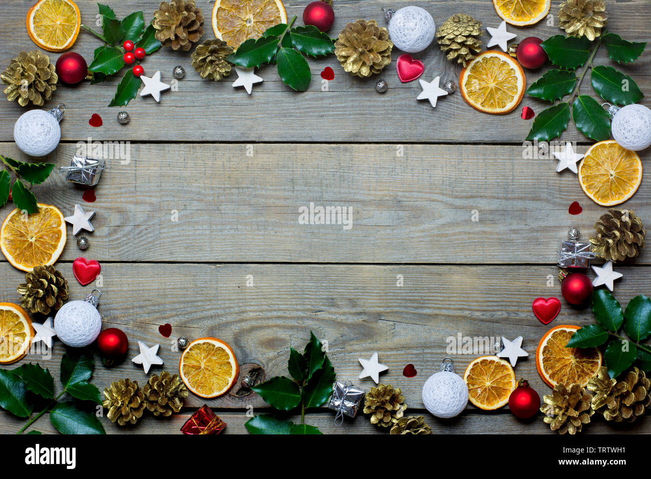 Weihnachten Zusammensetzung mit Orangenscheiben, Kegel, heiligen, Sterne, kleine Geschenkboxen, rote und weiße Kugeln und Herzen auf Holz- Hintergrund Stockfoto