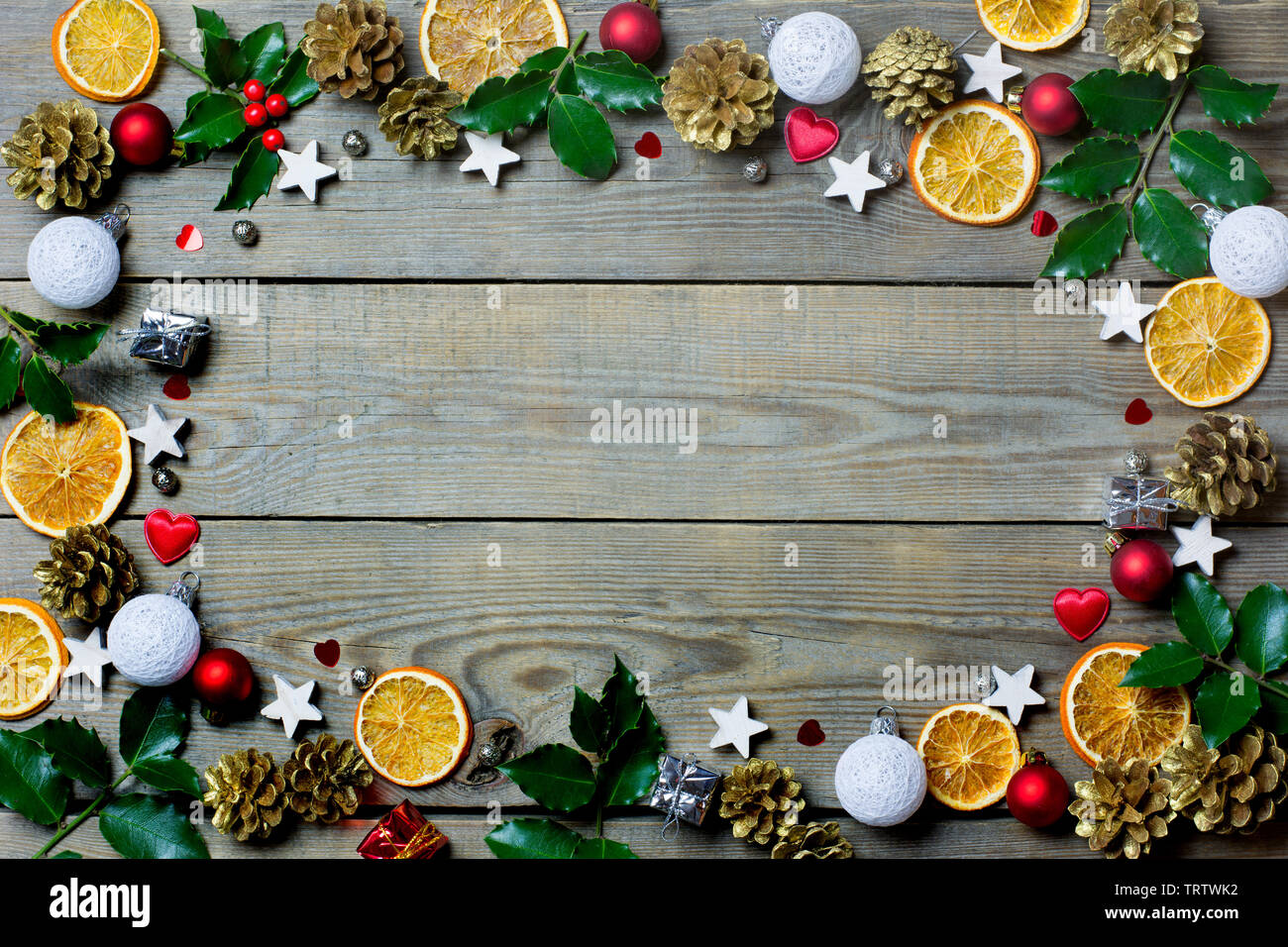 Weihnachten Zusammensetzung mit Orangenscheiben, Kegel, heiligen, Sterne, kleine Geschenkboxen, rote und weiße Kugeln und Herzen auf Holz- Hintergrund Stockfoto