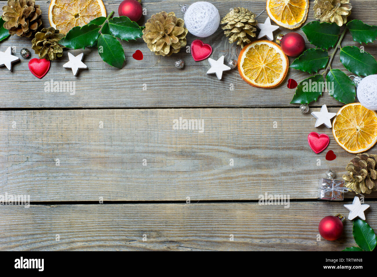 Weihnachten Zusammensetzung mit Orangenscheiben, Kegel, heiligen, Sterne, kleines Geschenk Safe, rote und weiße Kugeln und Herzen auf Holz- Hintergrund Stockfoto