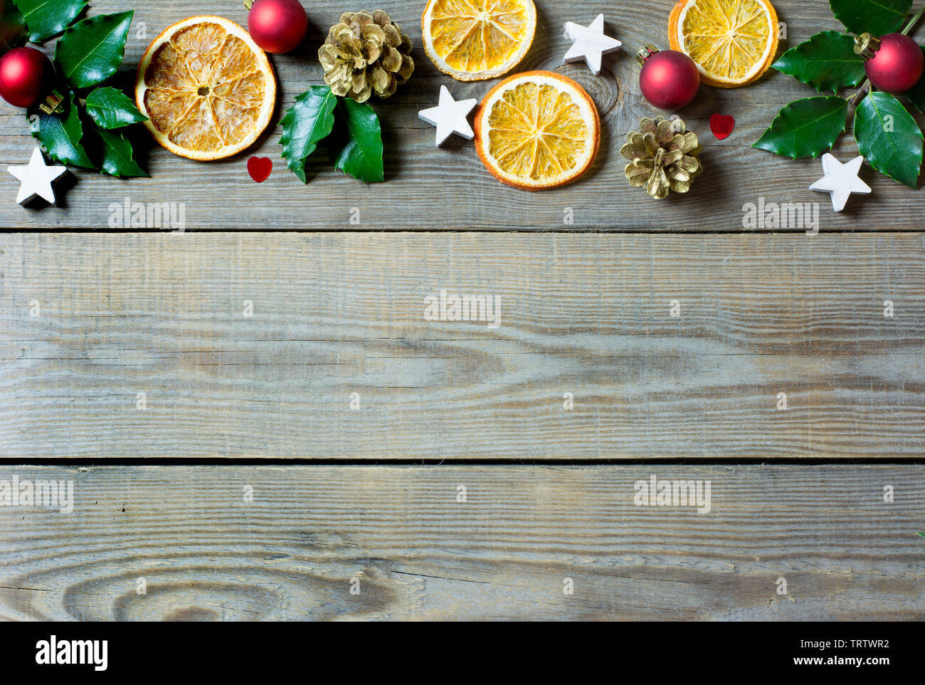 Weihnachten Zusammensetzung mit Orangenscheiben, Kegel, heiligen, Sterne, rote Kugeln und kleinen Herzen auf hölzernen Hintergrund Stockfoto