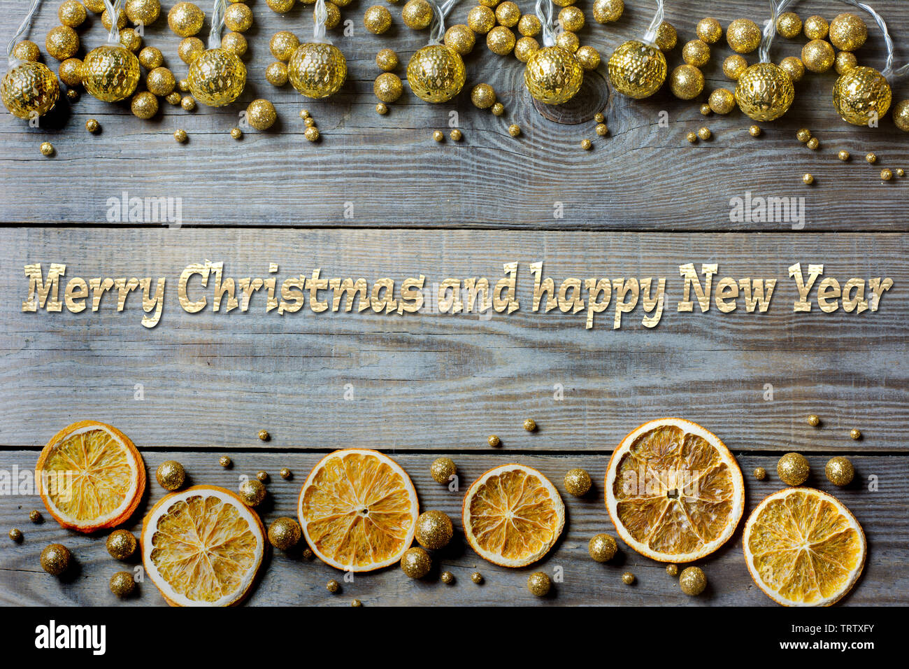 Weihnachten Zusammensetzung mit Orangenscheiben, Golden Lights und golden glitter Kugeln auf Holz- Hintergrund Stockfoto