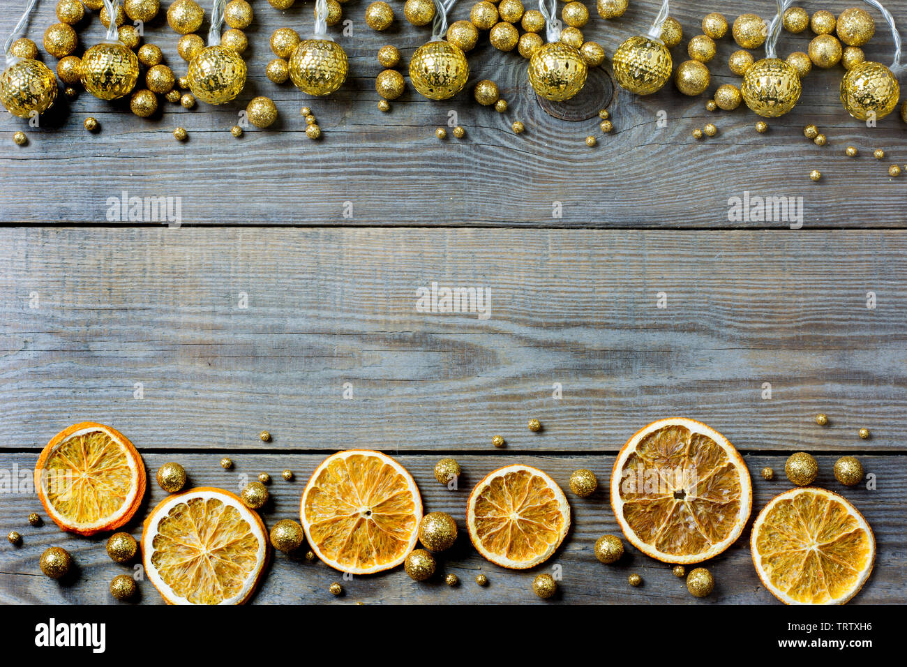 Weihnachten Zusammensetzung mit Orangenscheiben, Golden Lights und golden glitter Kugeln auf Holz- Hintergrund - Platz für Text Stockfoto