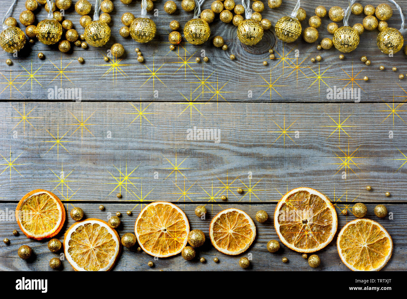 Weihnachten Zusammensetzung mit Orangenscheiben, Golden Lights, golden glitter Kugeln und Orange Stars auf Holzuntergrund - Platz für Text Stockfoto