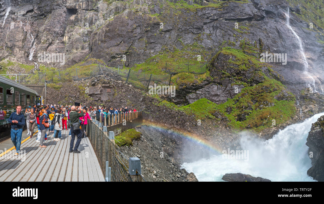 Fahrgäste aus dem Zug auf der Flam Bahn (flåmsbana) am Wasserfall Kjosfossen, Flåm, Sogn und Fjordane, Norwegen Stockfoto