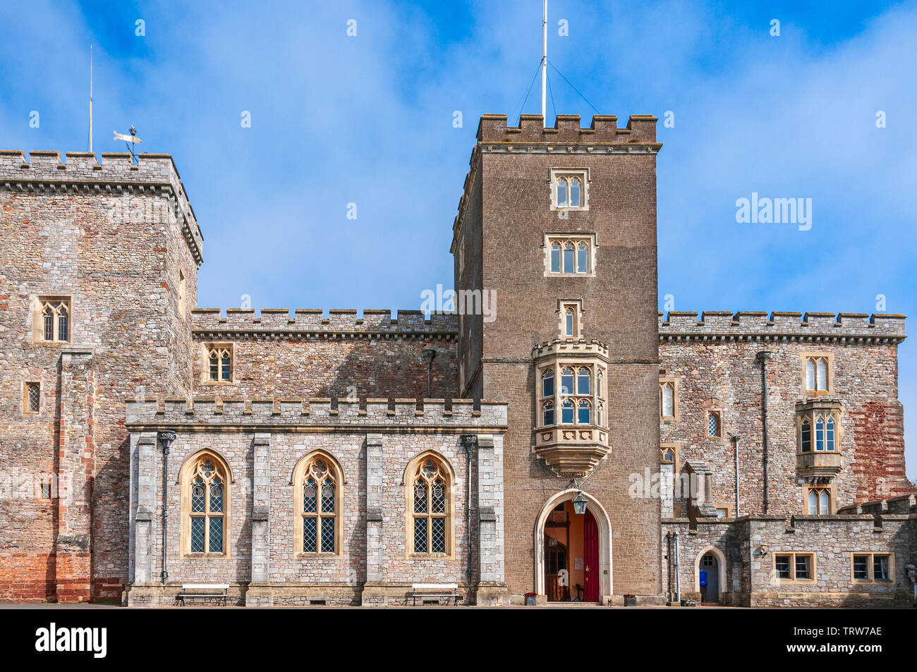 Eine befestigte mauve Farbige rechteckigen Turm mit attraktiven Windows Häuser der bogenförmige Eingang zum Hauptgebäude der Powderham Castle Stockfoto