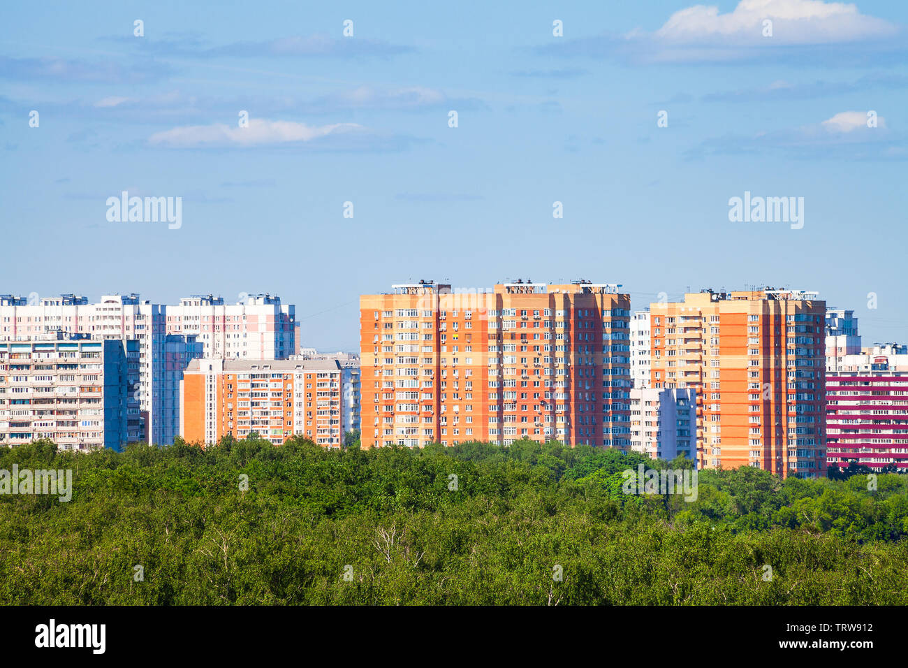Wohnhäuser und Green City Park unter blauem Himmel im sonnigen Sommertag Stockfoto