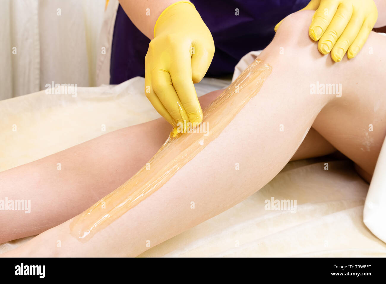 Methode der Haarentfernung Zuckerpaste zur Süßung c weiblichen Körper. Das Werk und die Methoden der Master angezeigt. Stockfoto
