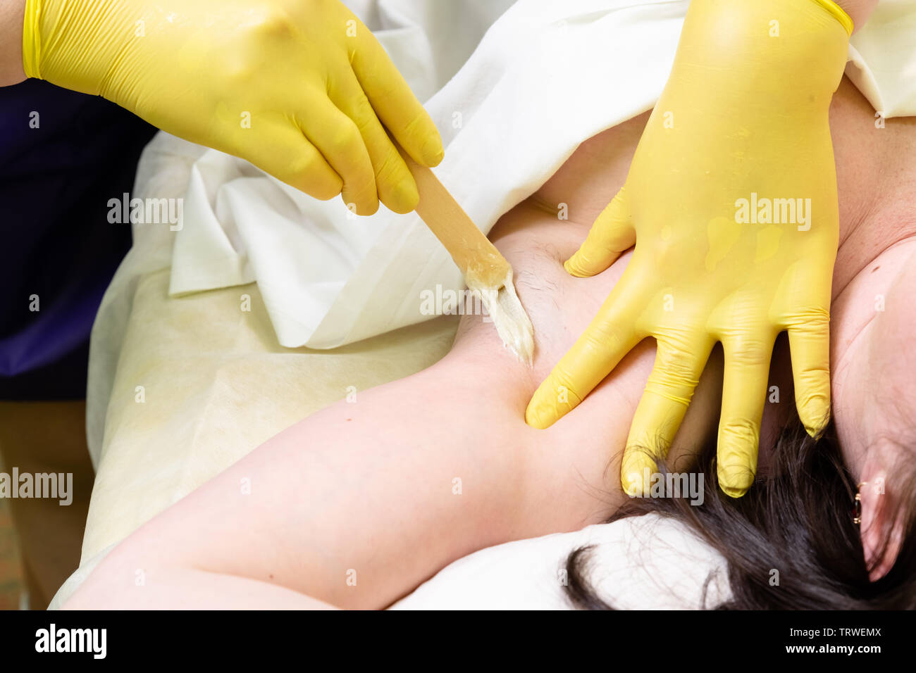 Methode der Haarentfernung Zuckerpaste zur Süßung c weiblichen Körper. Das Werk und die Methoden der Master angezeigt. Stockfoto