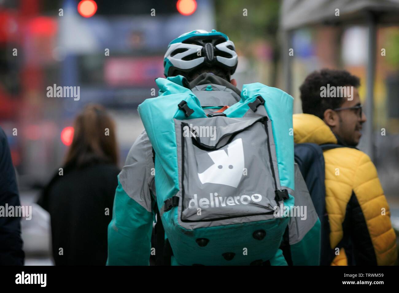 Ein Fahrer mit einer Lieferoo Online-Lieferung von Lebensmitteln fährt durch das Stadtzentrum von Manchester, Großbritannien Stockfoto