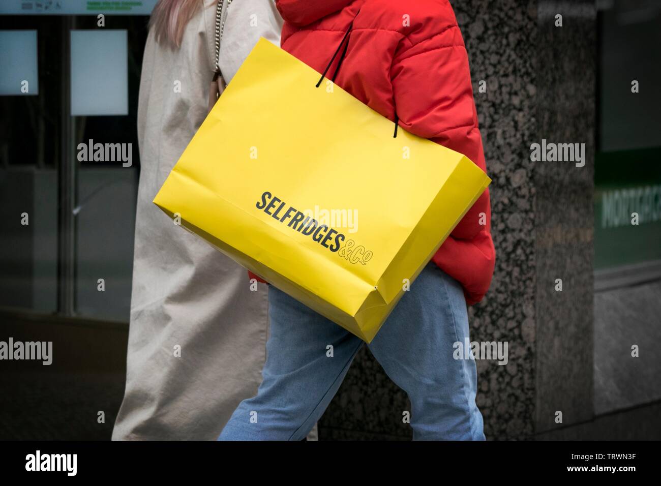 Eine Frau, die ein Selfridges Papier Karte Tragetasche Stockfoto